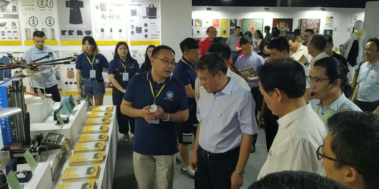 西安市委常委、副市长高杲在青博会听取明德学院师生讲解设计作品